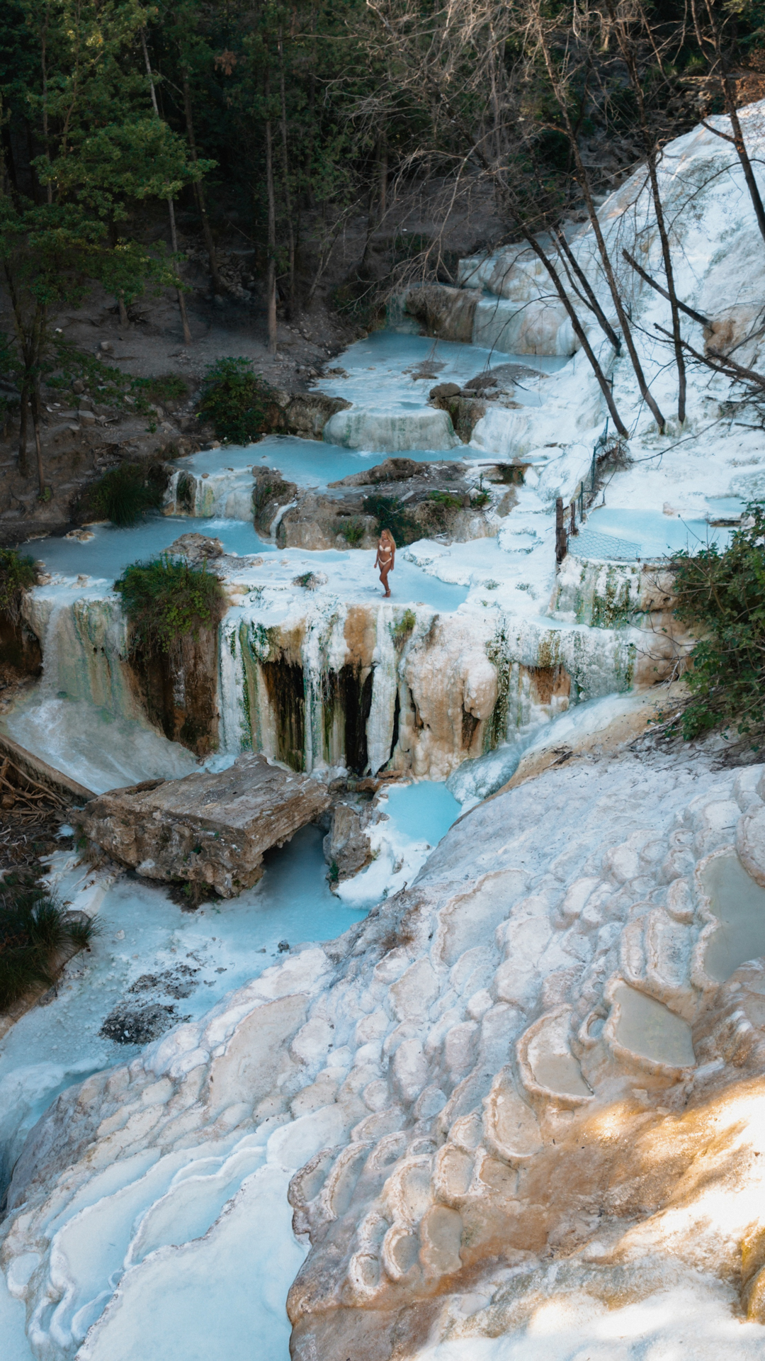 Bagni San Filippo Traveler standing at the natural blue pools of Bagni San Filippo in Tuscany, Italy