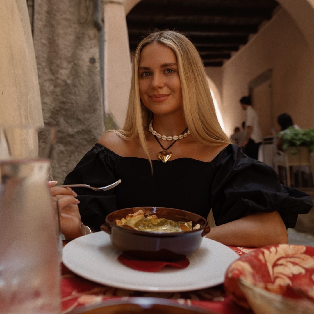 Food in Itay Woman enjoying Italian pasta at an outdoor restaurant in Lake Como, Italy.