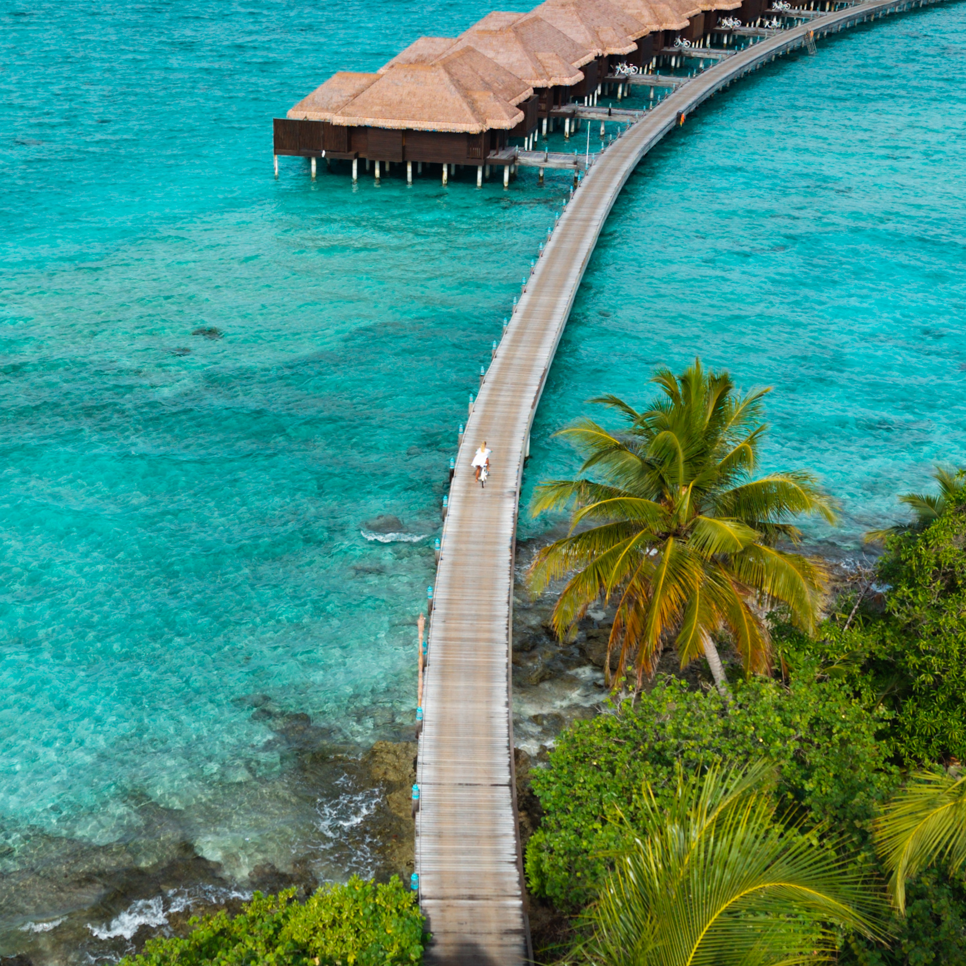 Wooden boardwalk leading to overwater bungalows in the Maldives