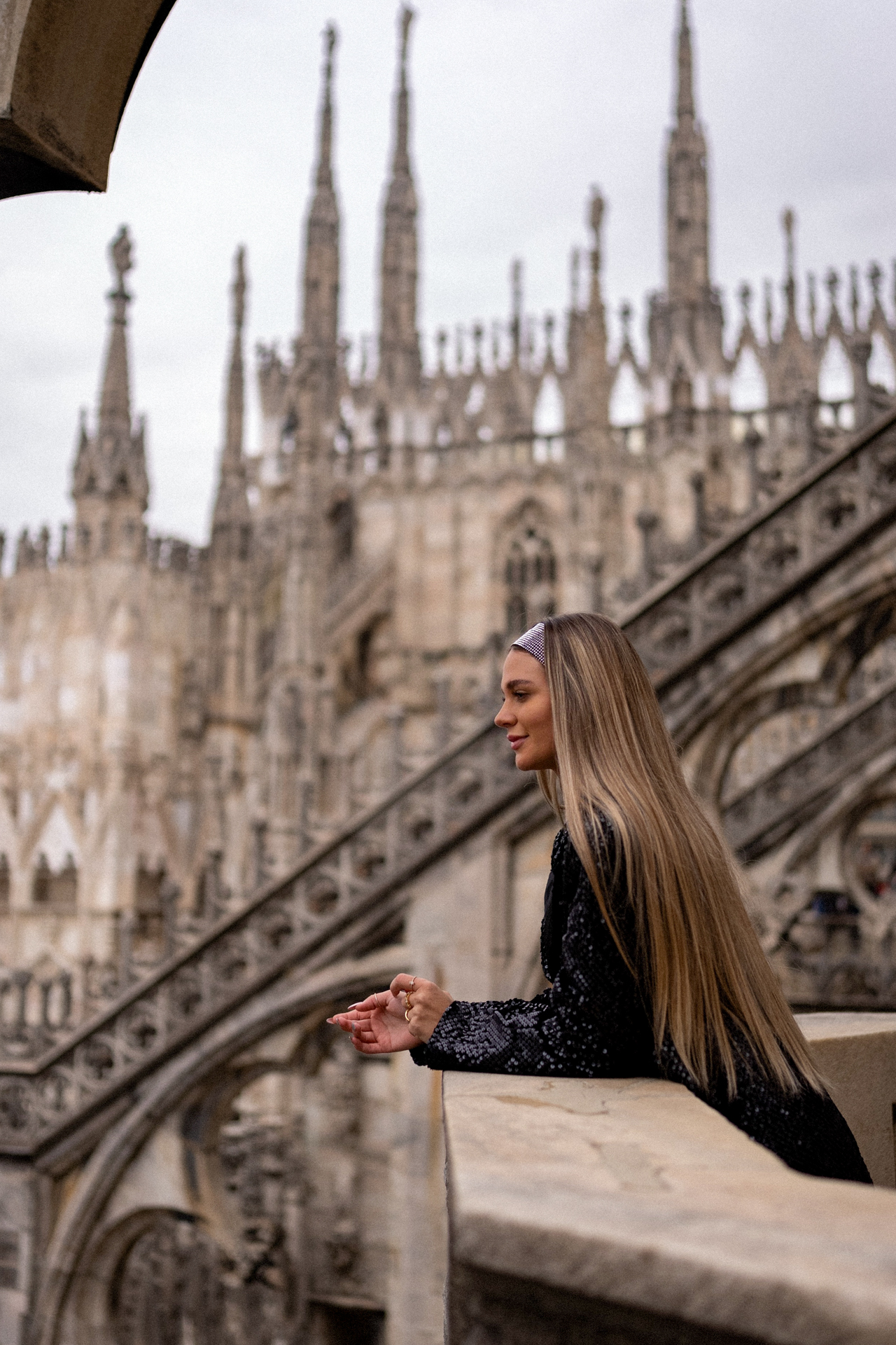 Woman on rooftop terrace of Milan Cathedral with gothic spires, Italy travel.