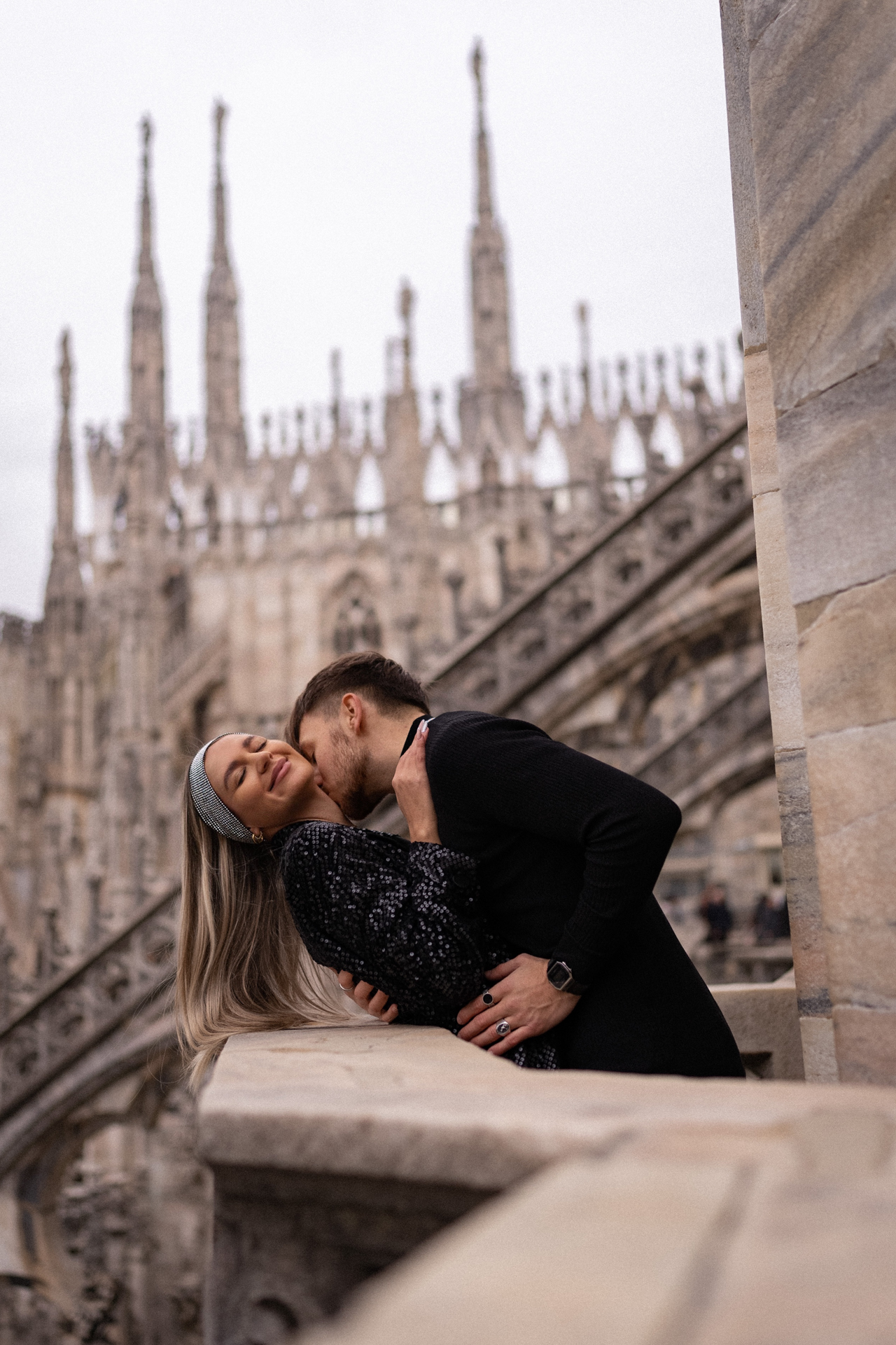 Couple sharing a kiss on the rooftop terraces of Milan Cathedral, Italy travel