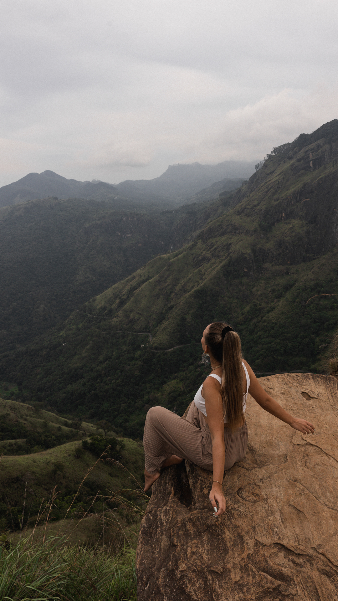 Little Adam's Peak Woman sitting on rock at Little Adam's Peak Hike in Ella, Sri Lanka