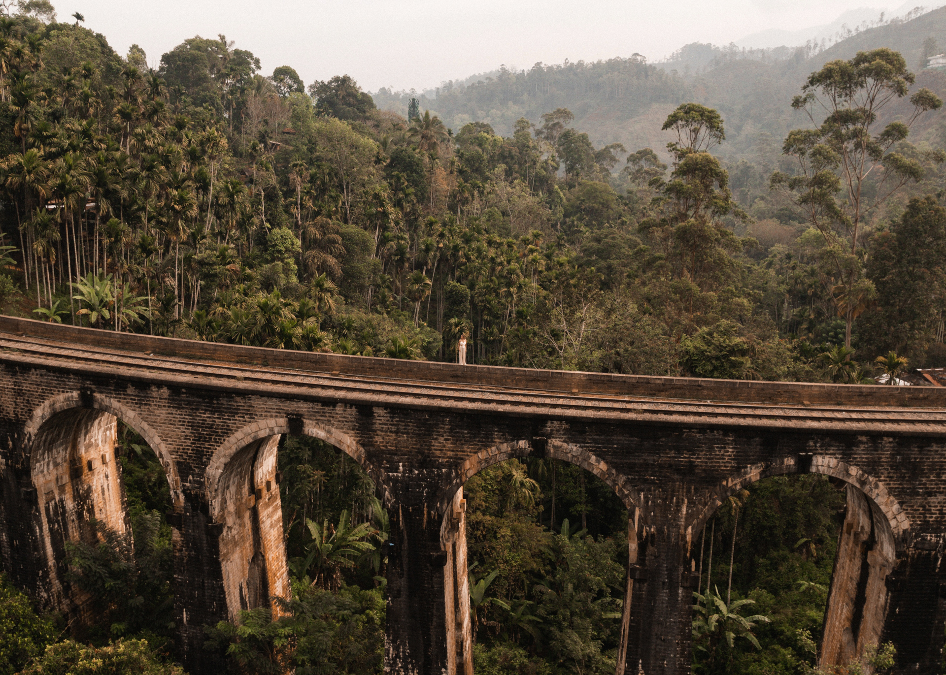 Aerial view of the Nine Arches Bridge stretching across the forested hills in Ella, Sri Lanka.