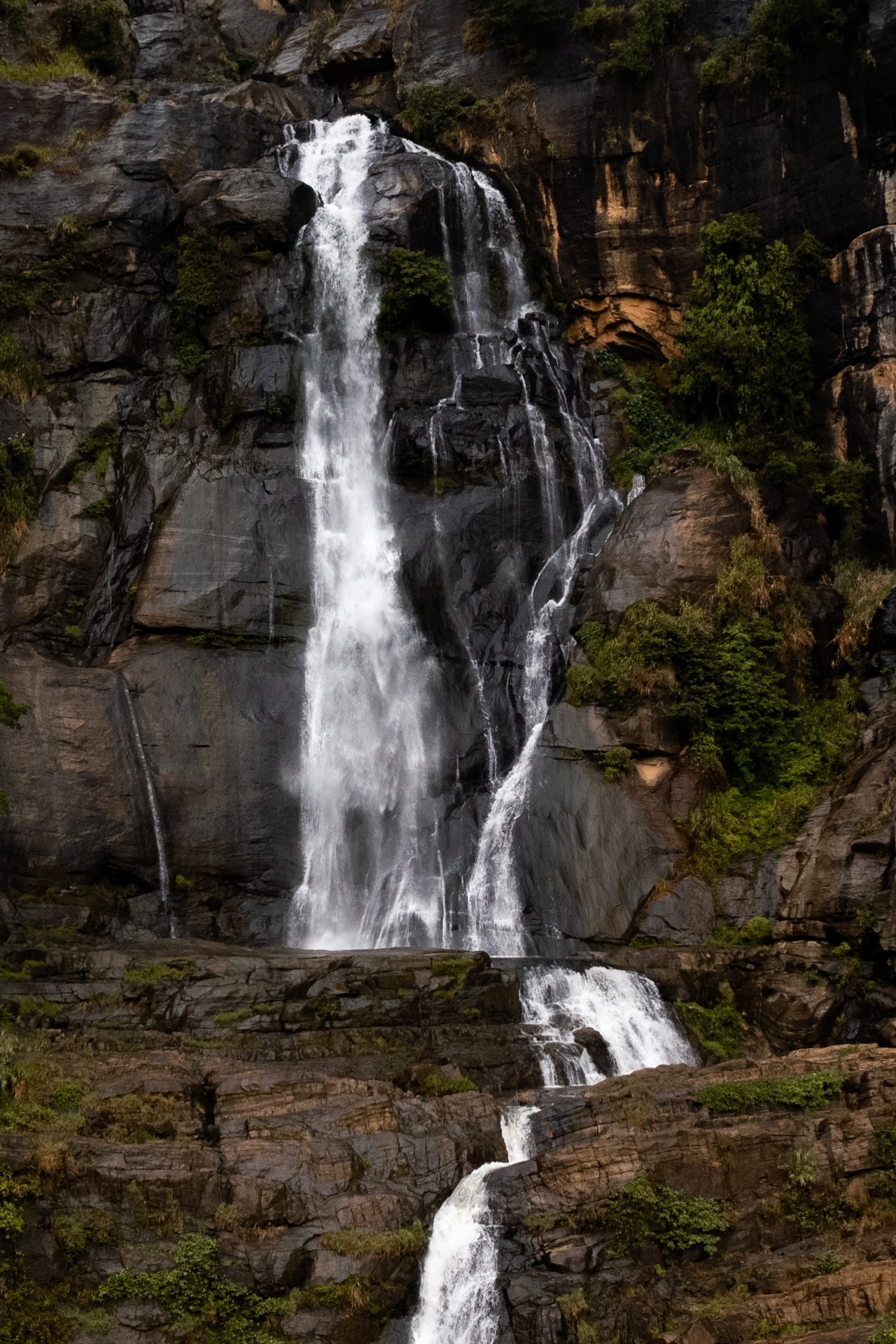 Ravana waterfall surrounded by rocky cliffs and greenery in Sri Lanka’s hill country.