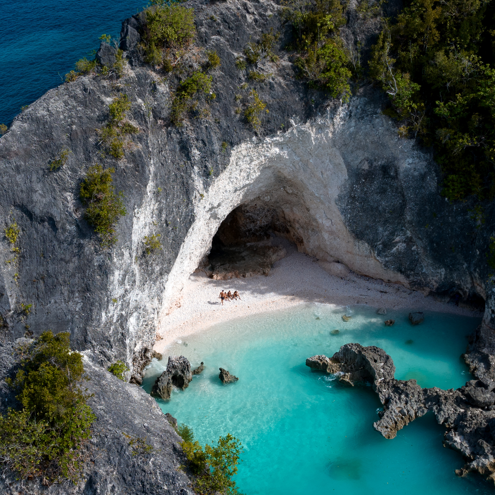 Secluded sandy beach inside rock cave with turquoise water, Banggai Laut Sulawesi, Indonesia