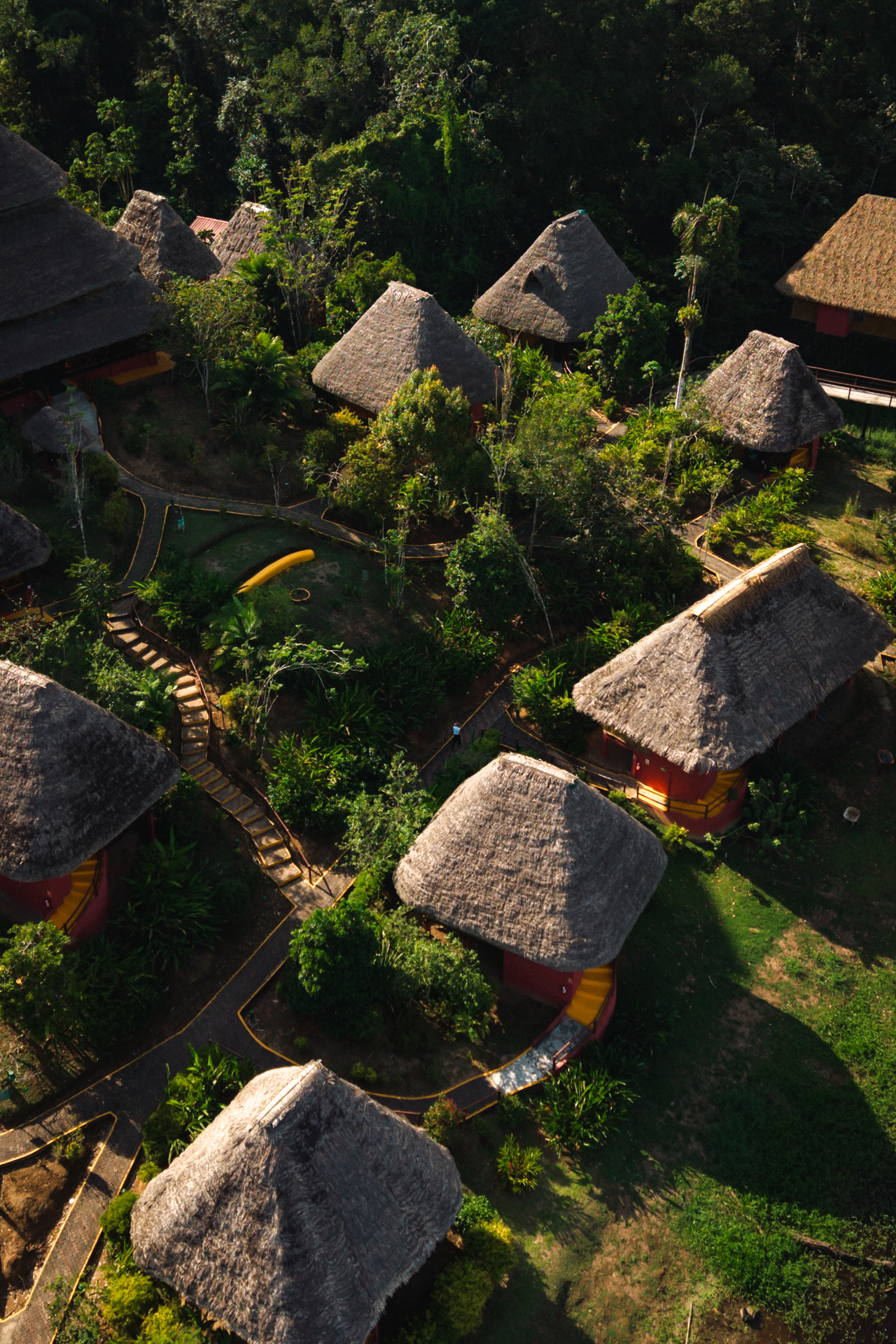 The Amazon Aerial view of traditional thatched-roof jungle lodges surrounded by lush greenery in the Amazon Rainforest of Ecuador.