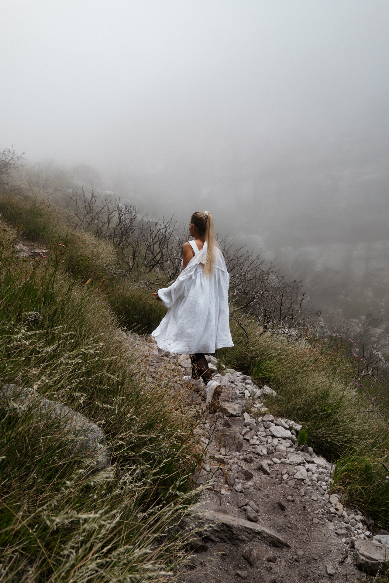 Table Mountain Woman walking along misty mountain trail on Table Mountain.