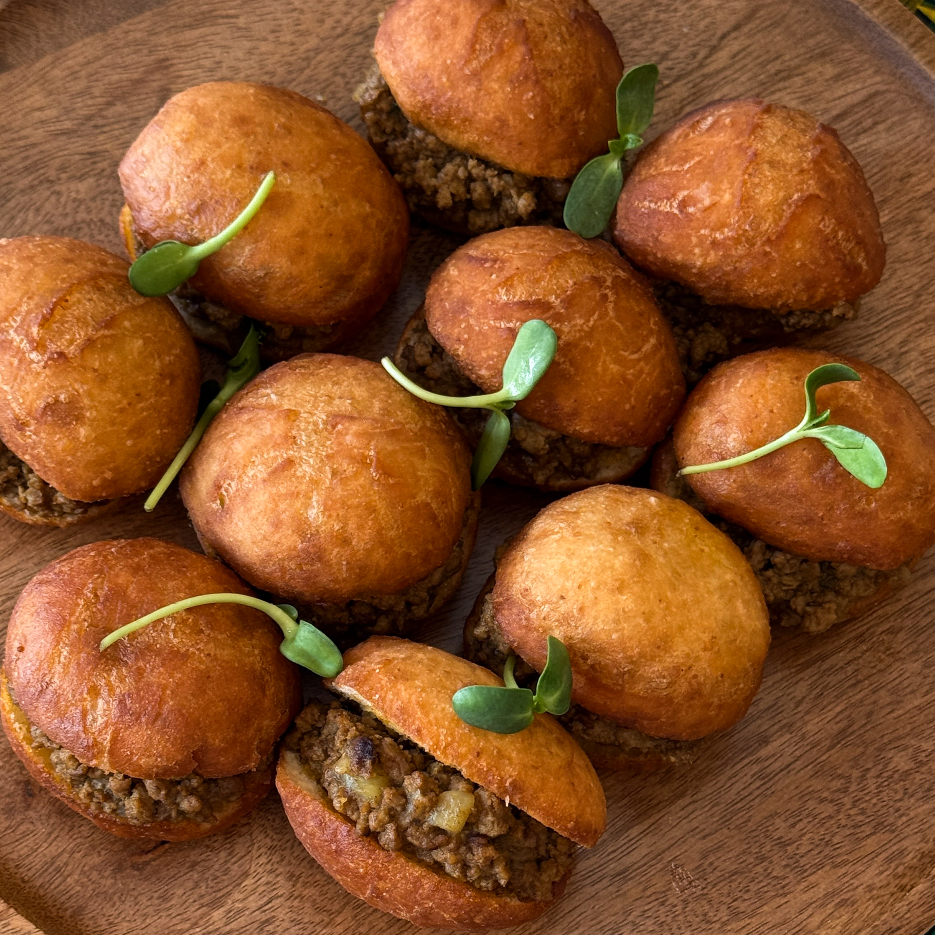 Food in Cape Town Traditional African vetkoek stuffed with savory mince on a wooden plate.
