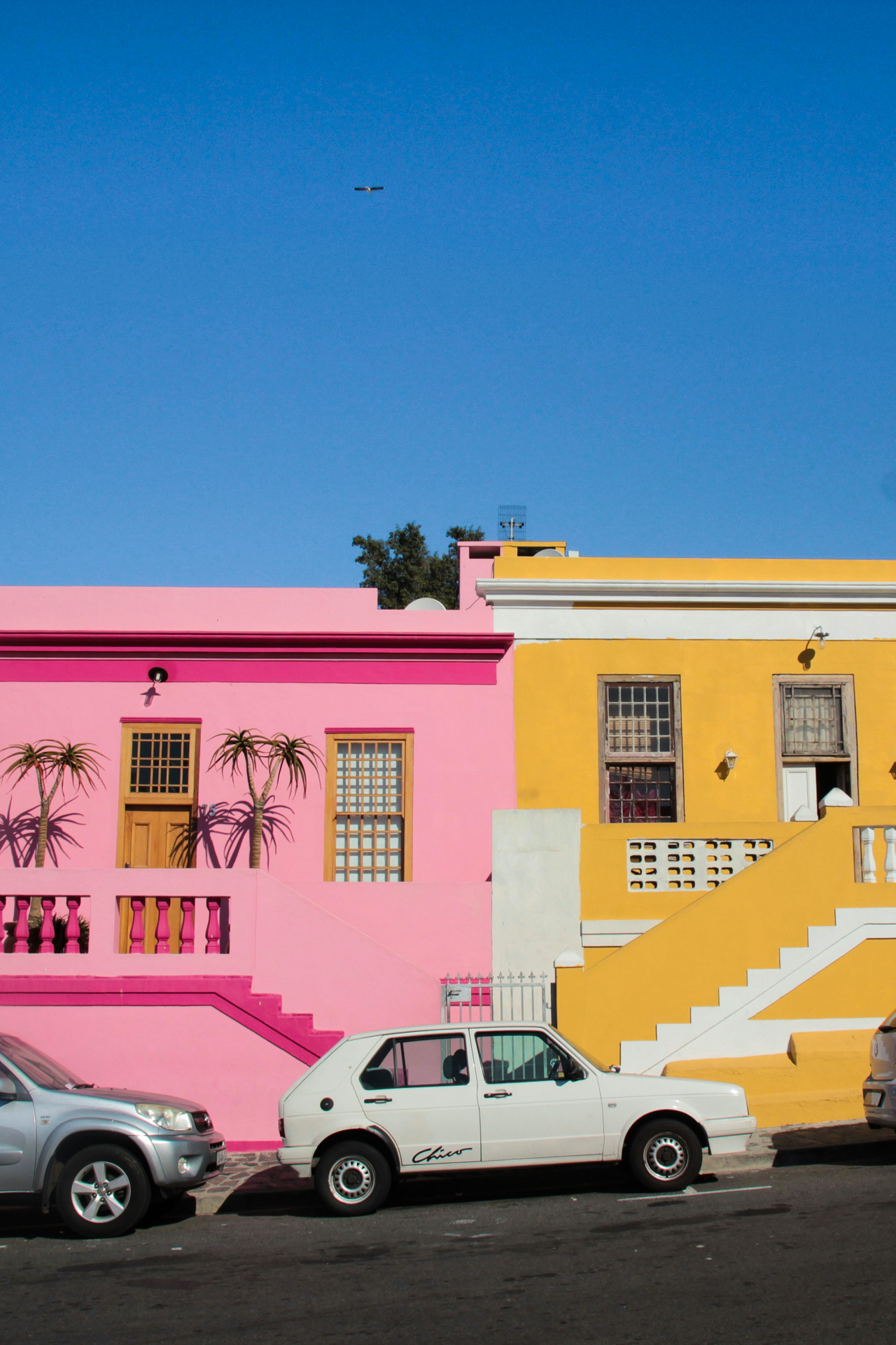 Boo-Kap Colorful street in Bo-Kaap, Cape Town, featuring bright pink and yellow houses.