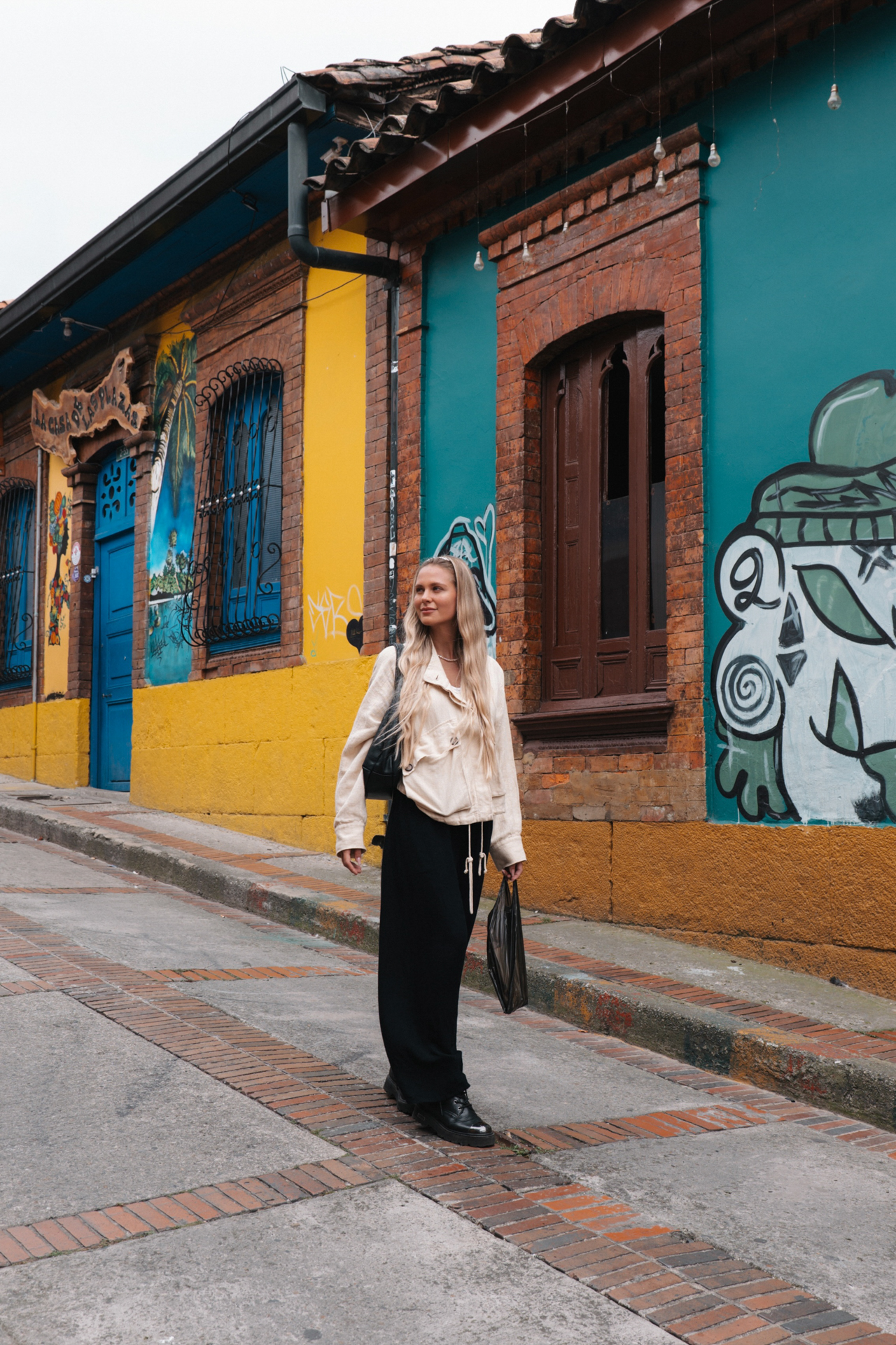 Bogotá Woman exploring the colorful streets of La Candelaria in Bogotá, Colombia, with vibrant murals and colonial architecture.