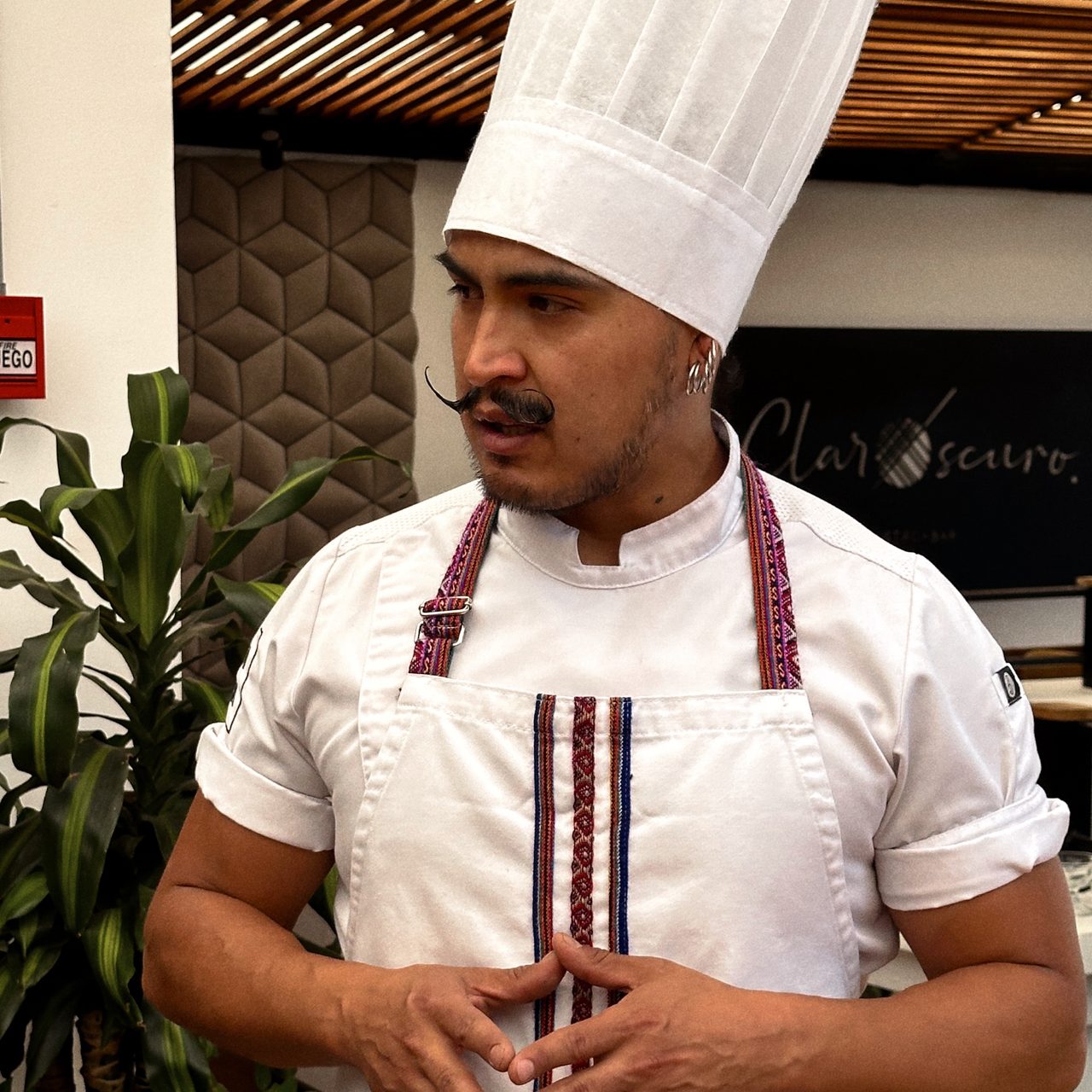 Food in Ecuador Ecuadorian chef wearing a white hat and apron preparing fresh local ingredients including strawberries and golden berries.