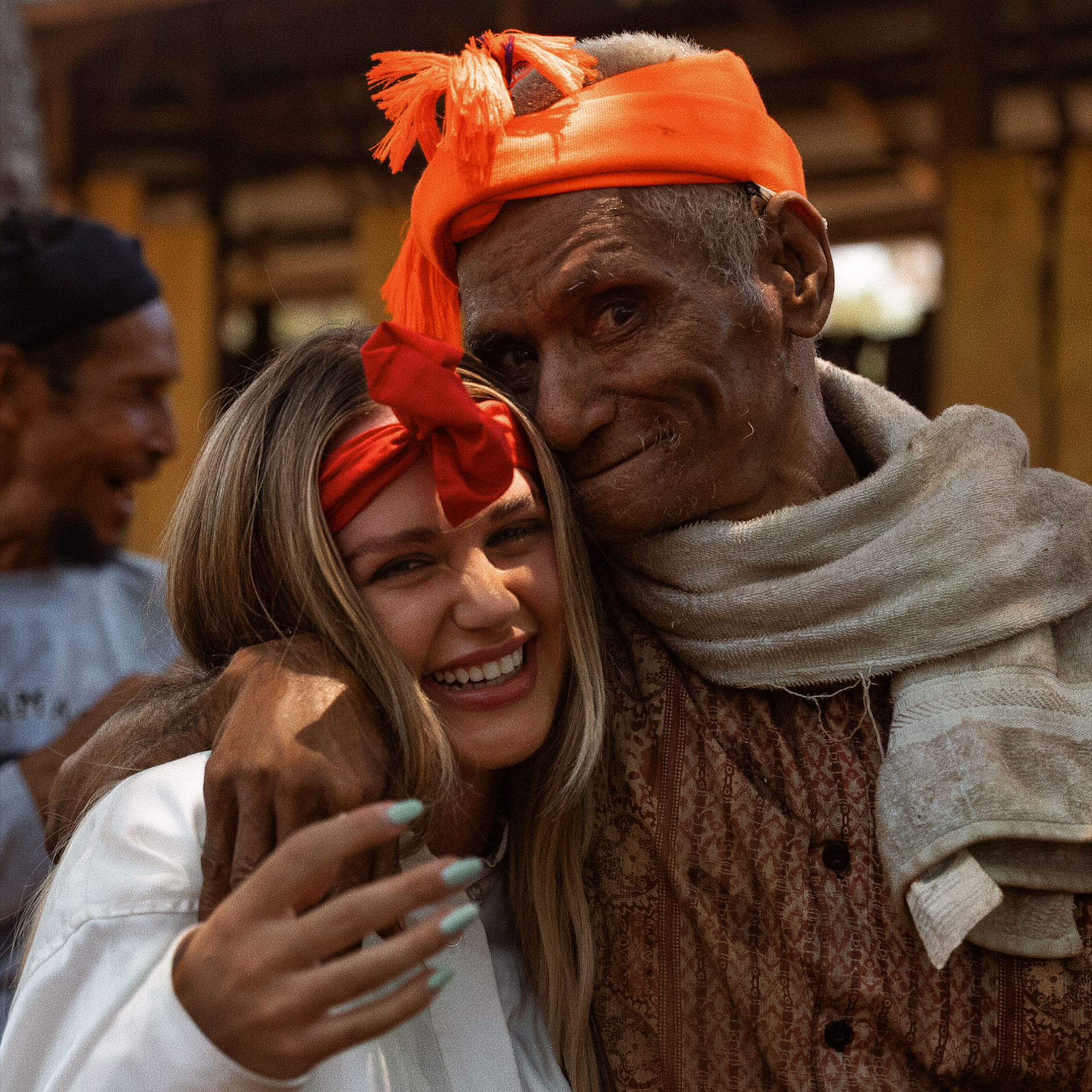 Culture in Indonesia Local elder warmly embraces a smiling traveler during a traditional gathering in Sumba.
