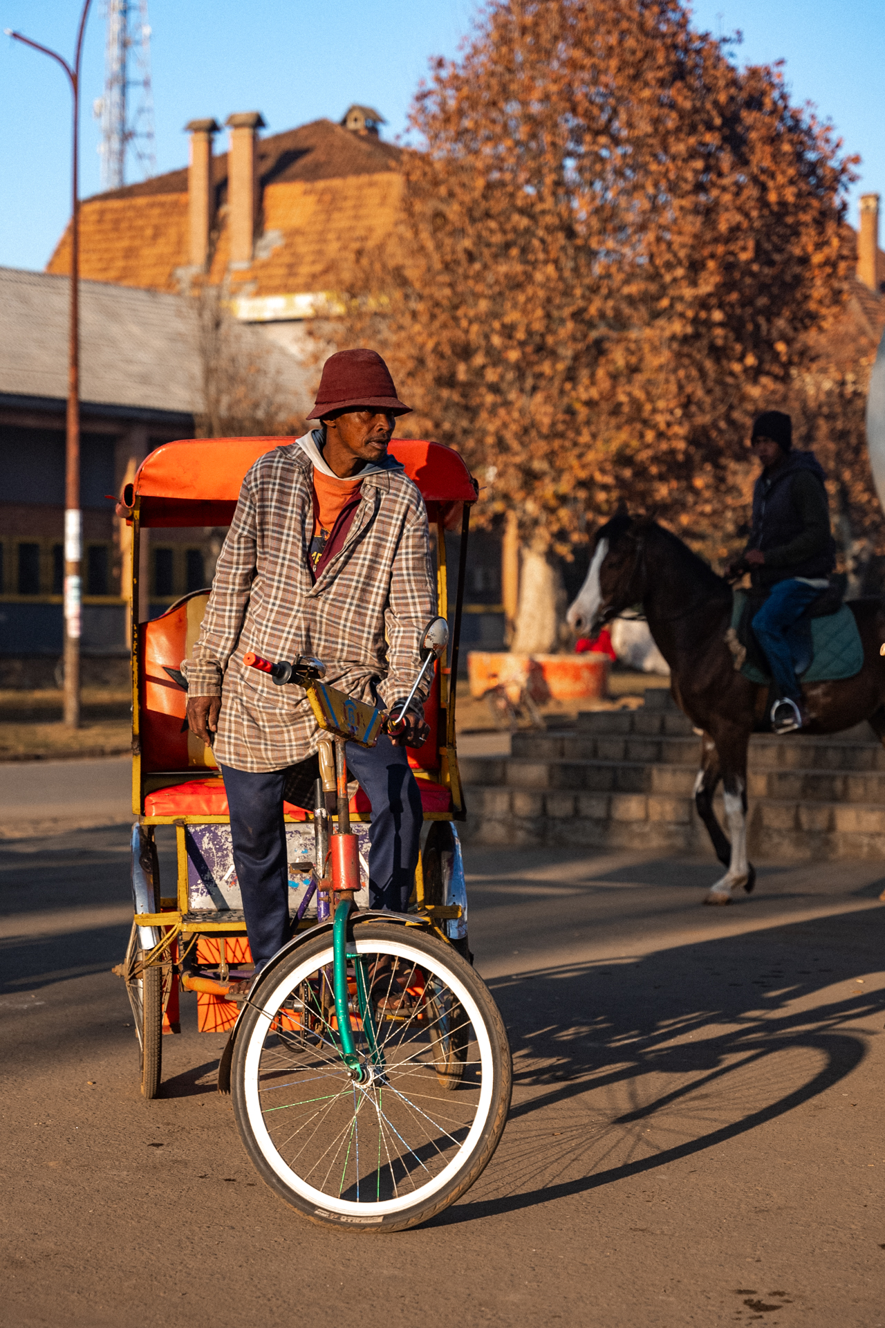 Antsirabe Local man riding a colorful rickshaw bicycle in Antsirabe in Madagascar.
