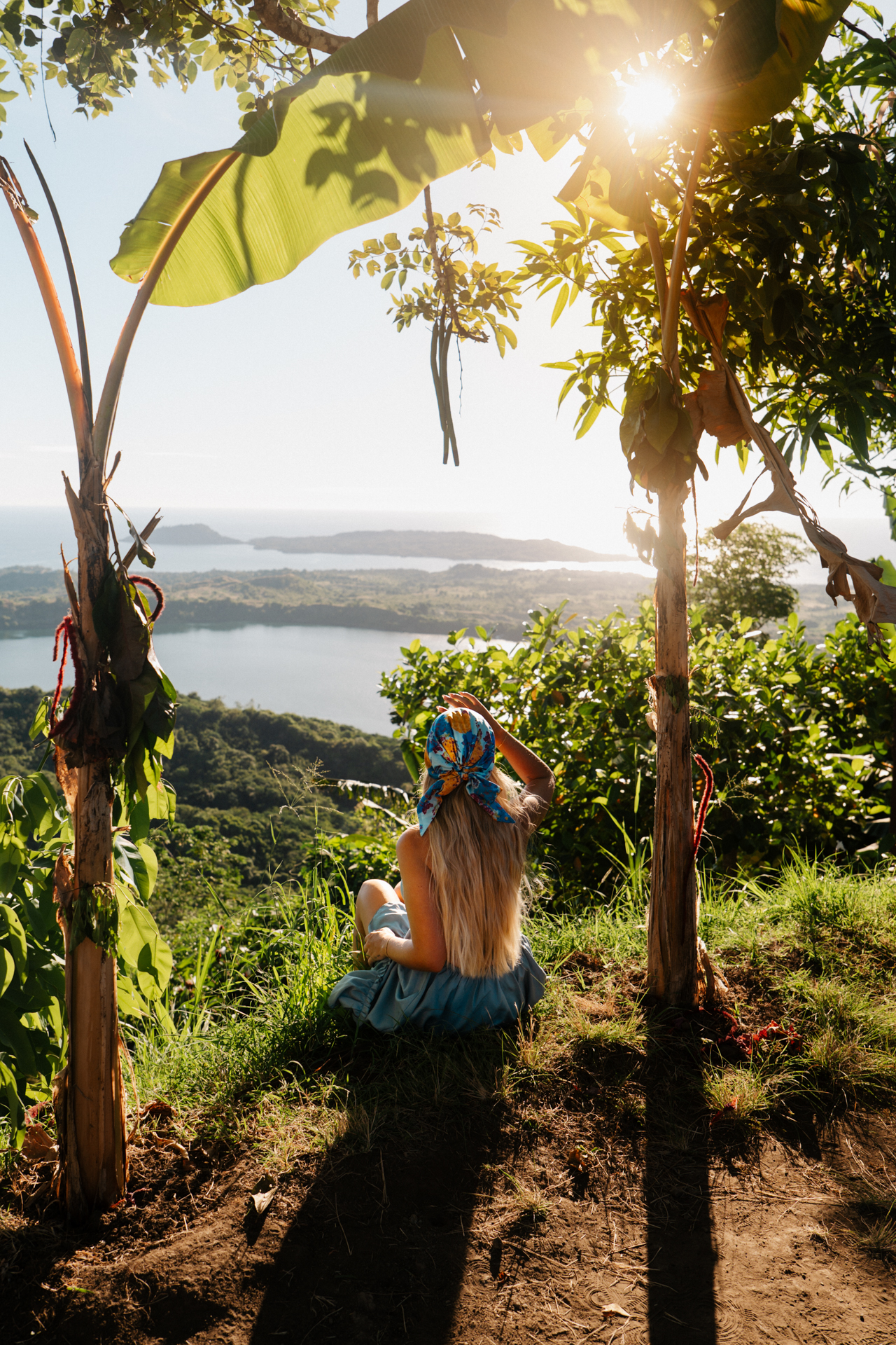 Nosy Be Woman sitting under banana trees overlooking Nosy be on Mont Passot in Madagascar.