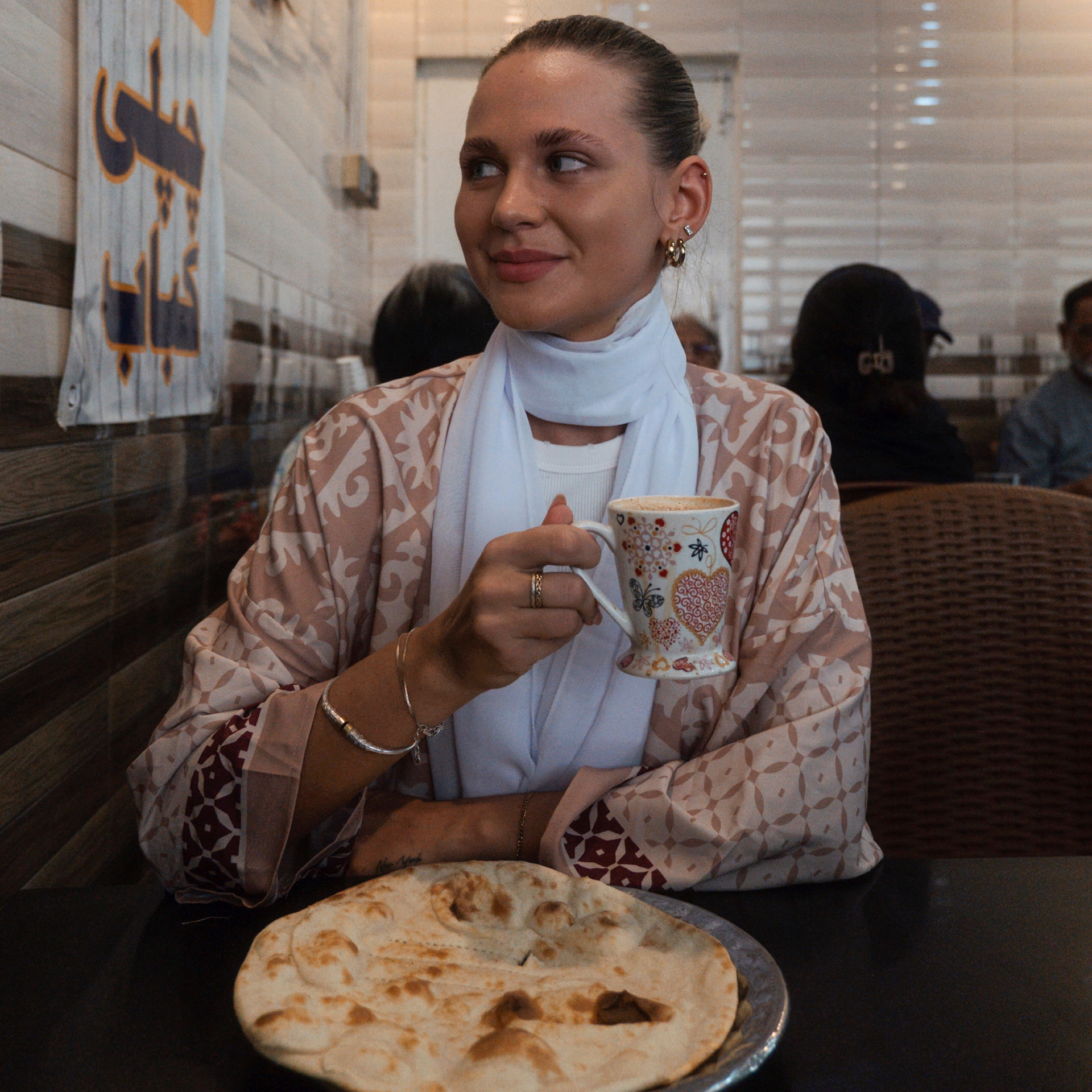 Food in Pakistan Woman drinking chai with naan in a traditional eatery in Pakistan