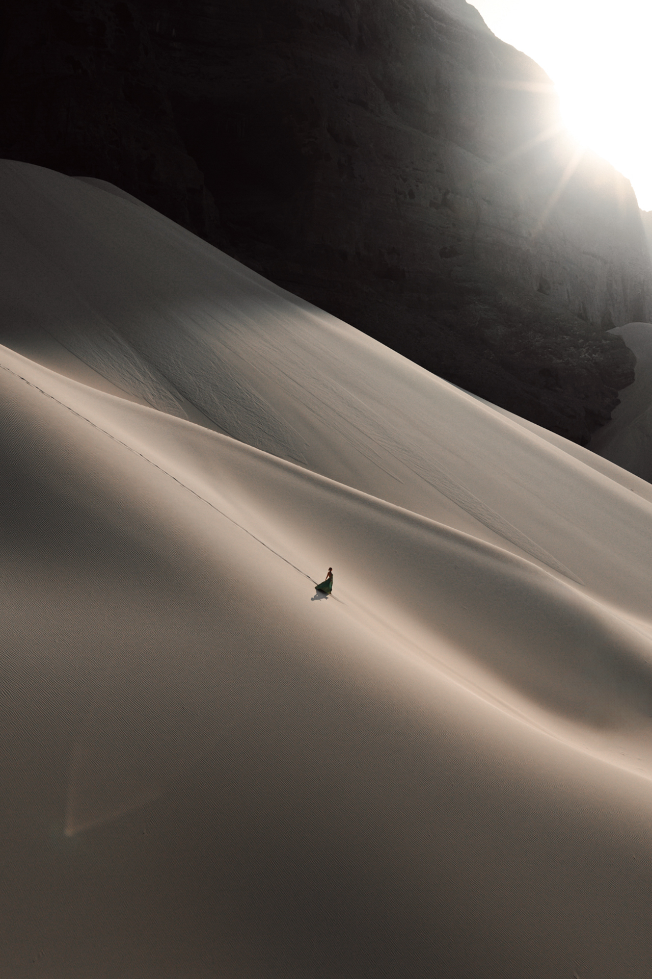 Arher Sand Dunes Traveler walking on vast golden Arher sand dunes of Socotra at sunset.